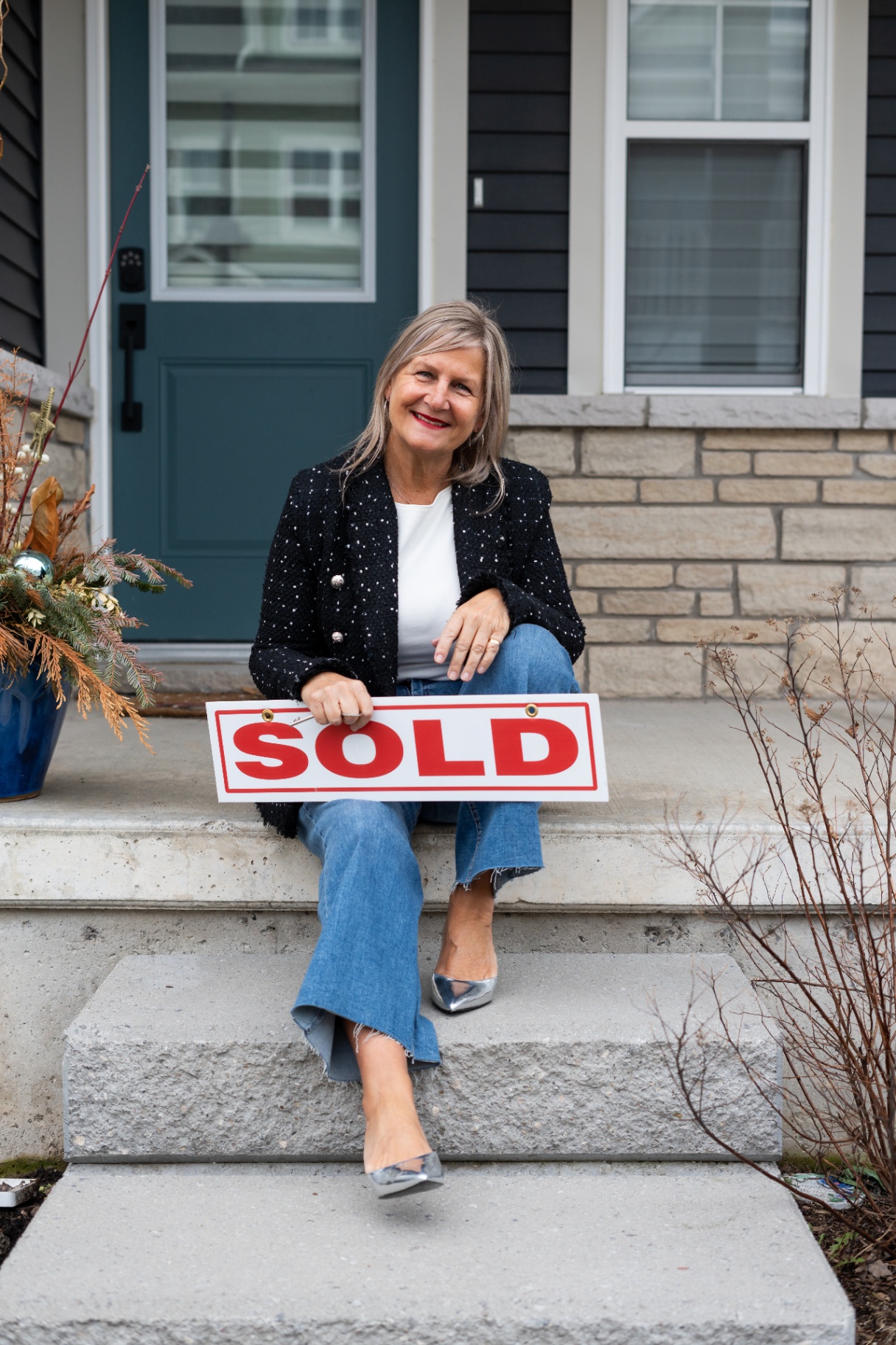Karen with a SOLD sign on a Niagara front step